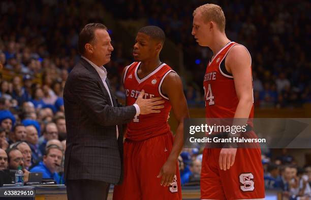 Head coach Mark Gottfried of the North Carolina State Wolfpack talks with Dennis Smith Jr. #4 and Maverick Rowan of the North Carolina State Wolfpack...