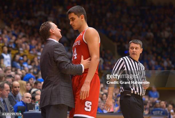 Head coach Mark Gottfried of the North Carolina State Wolfpack talks with Omer Yurtseven of the North Carolina State Wolfpack during their win...