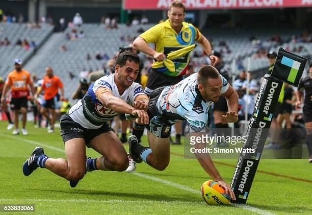 Matthew Evans of the Sharks scores a try in the tackle of Reimis Smith of the Bulldogs during the 2017 Auckland Nines match between the Cronulla...