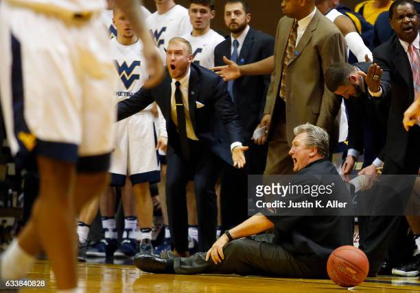 Coach Bob Huggins falls down arguing a call in the second half against the Oklahoma State Cowboys at the WVU Coliseum on February 4, 2017 in...