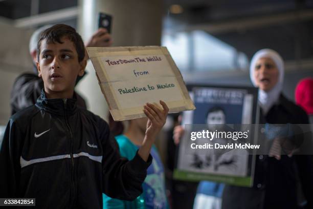 Boy holds a sign while demonstrating in support of a ruling by a federal judge in Seattle that grants a nationwide temporary restraining order...