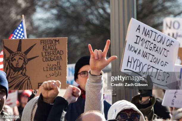 Demonstrators hold signs during a rally in front of the White House on February 4, 2017 in Washington, DC. The demonstration was aimed at President...