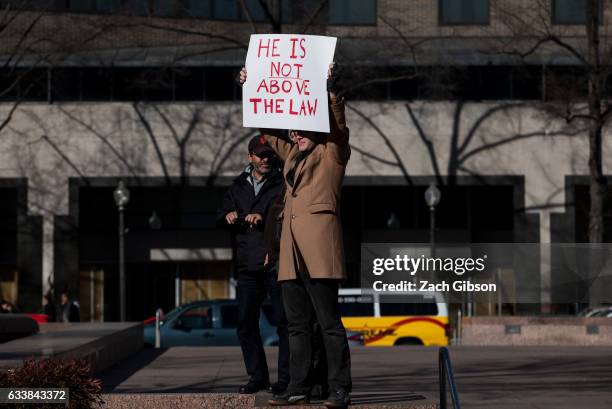 Man holds a sign as demonstrators march from the White House to the Capitol Building on February 4, 2017 in Washington, DC. The demonstration was...