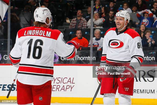 Ron Hainsey is congratulated by his teammate Elias Lindholm of the Carolina Hurricanes after scoring a second period goal against the New York...