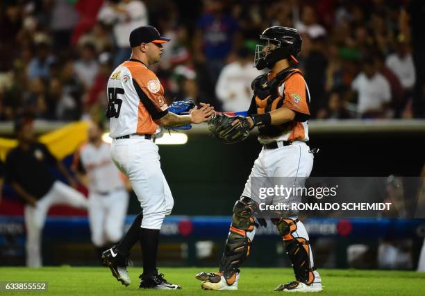 Pitcher Hassan Pena and catcher Francisco Arcia of Aguilas del Zulia from Venezuela celebrate victory over Alazanes de Granma from Cuba following...