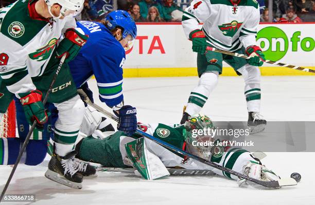 Devan Dubnyk of the Minnesota Wild battles Philip Larsen of the Vancouver Canucks for the puck during their NHL game at Rogers Arena February 4, 2017...