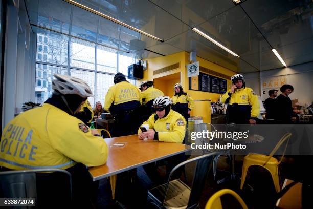 Police officers of a bike unit of the Philadelphia Police Dept. Rest at a coffee shop after serving and protecting citizens at a peace full protest....