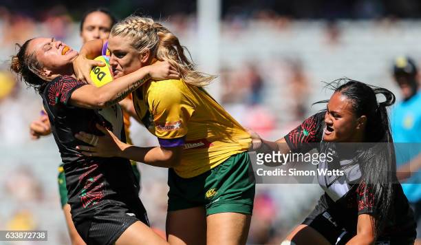 Renae Kunst of the Jillaroos is tackled by Amber Kani and Lilieta Maumau of the Black Ferns during the 2017 Auckland Nines match between the...