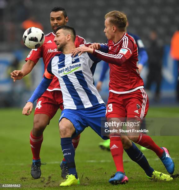 Vedad Ibisevic of Berlin is challenged by Florent Hadergjonaj and Anthony Jung of Ingolstadt during the Bundesliga match between Hertha BSC and FC...