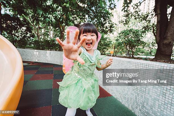 little girl smiling at camera in playground - feenkostüm stock-fotos und bilder