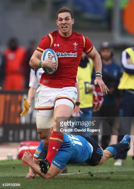 George North of Wales evades the attempted tackle from Leonardo Ghiraldini of Italy enroute to scoring his team's third try during the RBS Six...