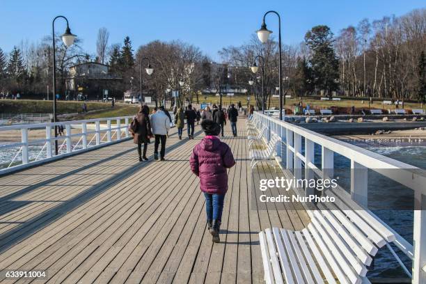 People walking at the Orlowo beach near the Orlowski Cliff are seen on 5 February 2017 in Gdynia, Poland .