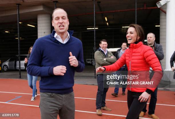 Britain's Catherine, Duchess of Cambridge and Britain's Prince William, Duke of Cambridge share a joke after running in a relay race, during a...
