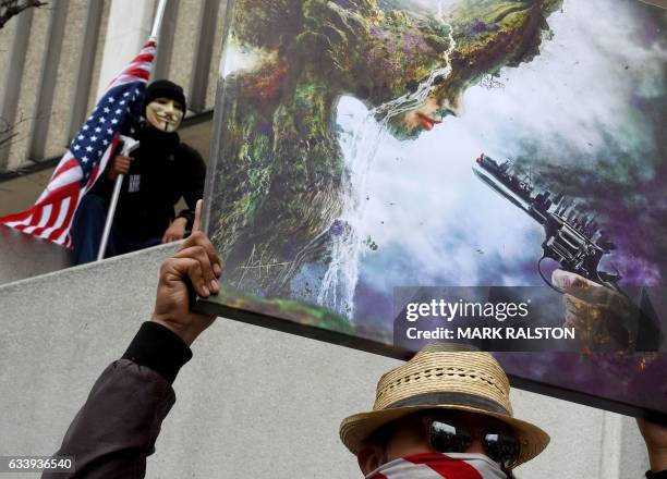 Demonstrators hold signs after marching to the Federal Building in protest against the executive order fast-tracking the Keystone XL and Dakota...