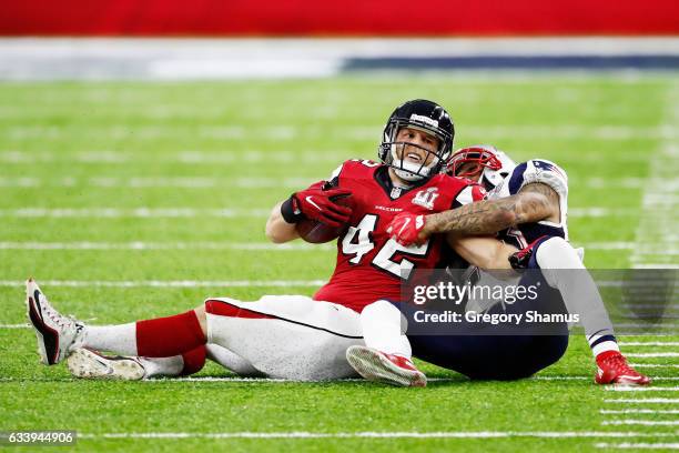 Patrick DiMarco of the Atlanta Falcons is tackled by Patrick Chung of the New England Patriots in the first quarter during Super Bowl 51 at NRG...