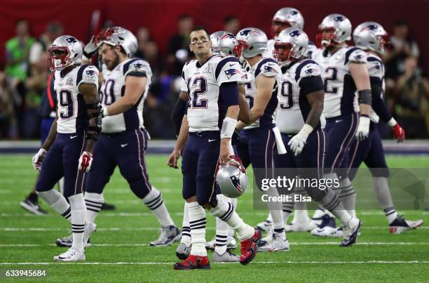 Tom Brady of the New England Patriots walks off the field with teammates after a fumble in the second quarter against the Atlanta Falcons during...