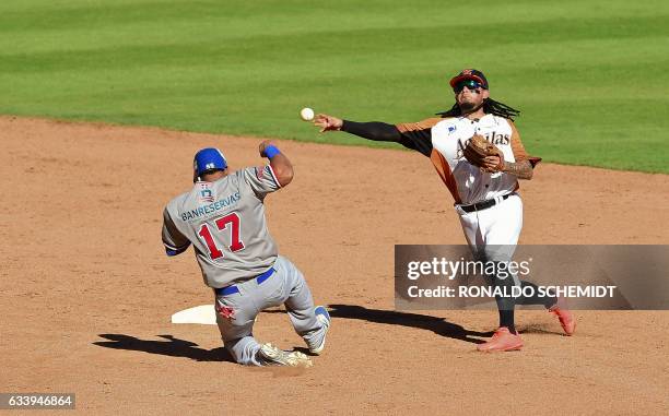 Diory Hernandez of Tigres del Licey of the Dominican Republic tags out in second base Freddy Galvis of Aguilas del Zulia of Venezuela during the...