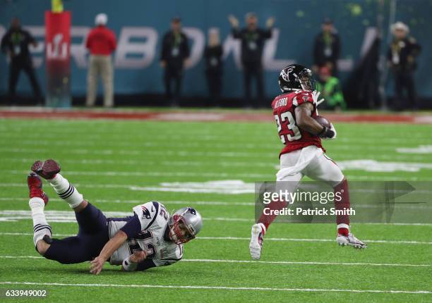 Tom Brady of the New England Patriots attempts to tackle Robert Alford of the Atlanta Falcons after an interception in the second quarter during...