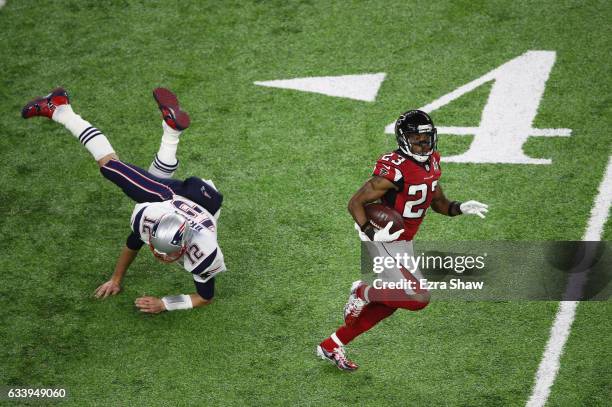 Tom Brady of the New England Patriots attempts to tackle Robert Alford of the Atlanta Falcons after an interception in the second quarter during...