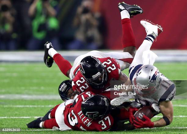 Julian Edelman of the New England Patriots makes a 23 yard catch in the fourth quarter against Ricardo Allen and Keanu Neal of the Atlanta Falcons...