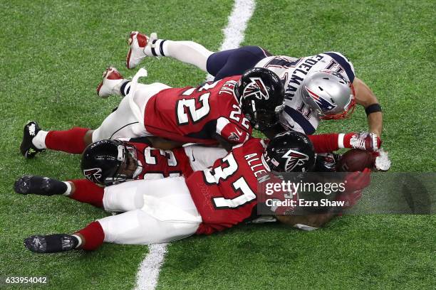 Julian Edelman of the New England Patriots makes a 23 yard catch in the fourth quarter against Ricardo Allen, Robert Alford and Keanu Neal of the...