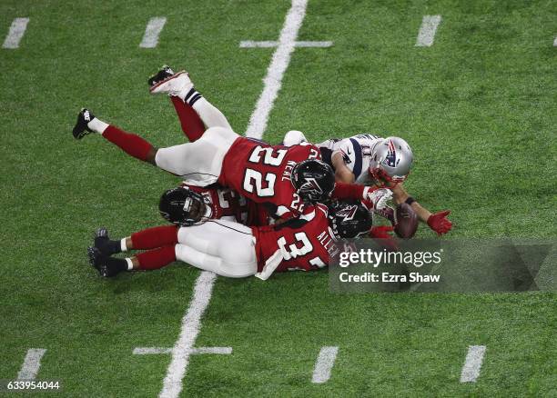 Julian Edelman of the New England Patriots makes a 23 yard catch in the fourth quarter against Ricardo Allen, Robert Alford and Keanu Neal of the...