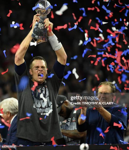 Tom Brady of the New England Patriots holds the Vince Lombardi Trophy as Head coach Bill Belichick looks on after defeating the Atlanta Falcons 34-28...