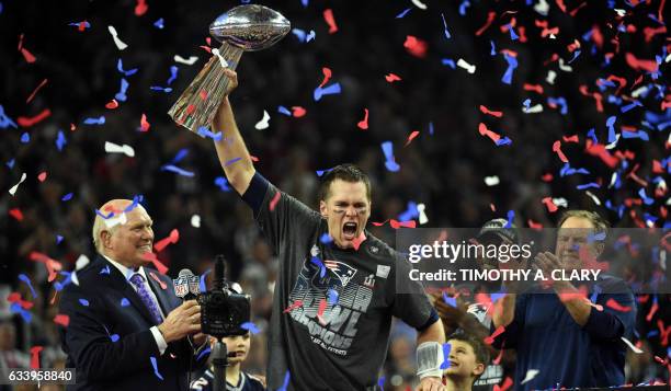 Tom Brady of the New England Patriots holds the Vince Lombardi Trophy as Head coach Bill Belichick looks on after defeating the Atlanta Falcons 34-28...