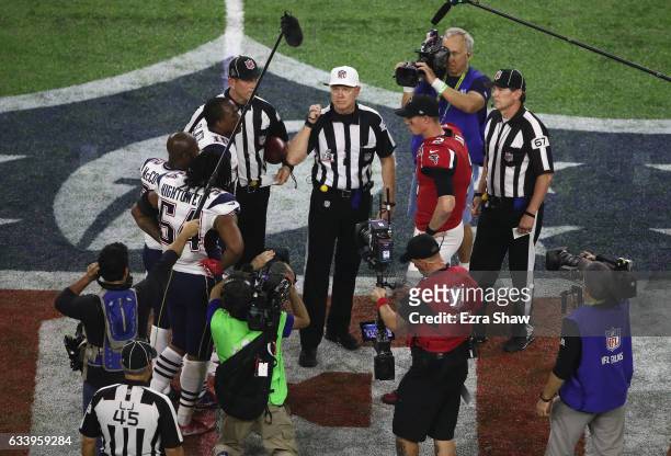 Matt Ryan of the Atlanta Falcons awaits the overtime coin toss with Dont'a Hightower, Devin McCourty and Matthew Slater of the New England Patriots...