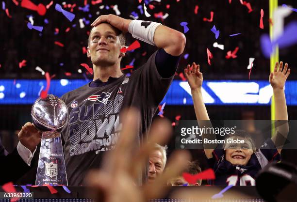 New England Patriots quarterback Tom Brady and his son celebrate with the Lombardi trophy after the Patriots defeated the Atlanta Falcons in Super...