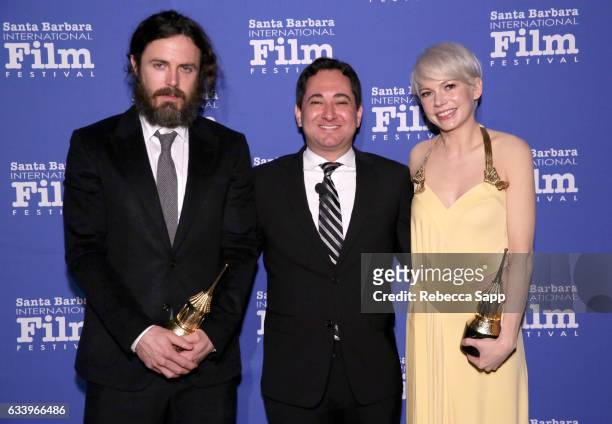 Actor Casey Affleck, moderator Scott Feinberg and actress Michelle Williams pose backstage with the Cinema Vanguard Award during the 32nd Santa...