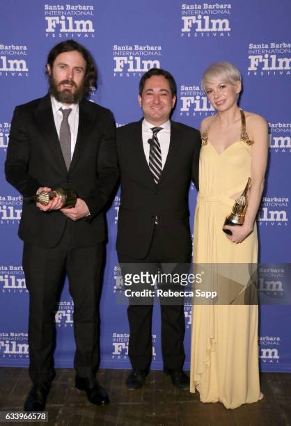 Actor Casey Affleck, moderator Scott Feinberg and actress Michelle Williams pose backstage with the Cinema Vanguard Award during the 32nd Santa...