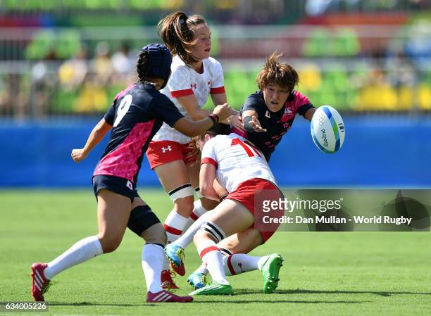 Makiko Tomita of Japan offloads the ball as she is tackled by Hannah Darling of Canada during the Women's Rugby Sevens Pool C match between Canada...