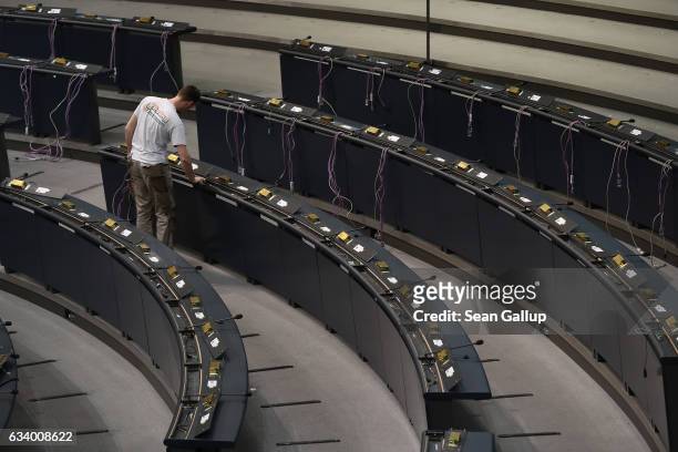 Worker prepares the electrical installations at the seating of parliamentarians in the plenary hall of the Bundestag in preparation for the upcoming...