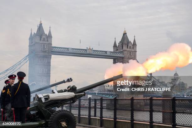 Members of the Honourable Artillery Company fire a 62 round royal gun salute from the Gun Wharf outside the Tower of London with Tower Bridge seen in...