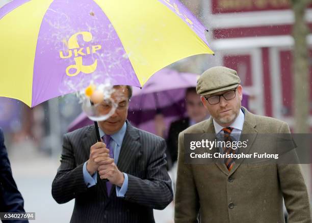 Leader Paul Nuttall and former Leader Nigel Farage MEP dodge an egg thrown by a youth as they arrive in Stoke-On-Trent for a public meeting this...