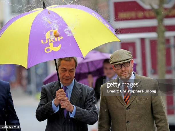 Leader Paul Nuttall and former Leader Nigel Farage MEP dodge an egg thrown by a youth as they arrive in Stoke-On-Trent for a public meeting this...