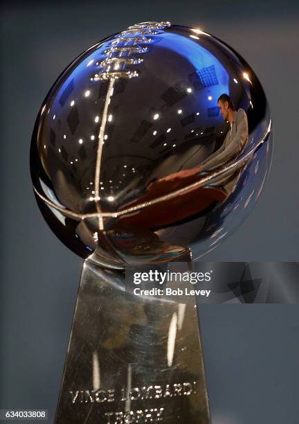 Super Bowl LI MVP Tom Brady reflection in the Vince Lmbardi Trophy as he talks with the media about their win over the Atlanta Falcons on February 6,...