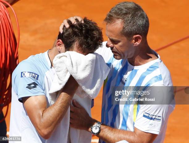 Guido Pella of Argentina looks dejected as Daniel Orsanic captain of Argentina cheers him up during a singles match between Guido Pella and Fabio...