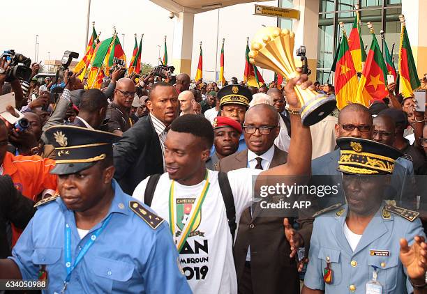 Fans cheer as Cameroon's team captain and forward Benjamin Moukandjo holds up the winner's trophy as he and the national football team arrive home to...