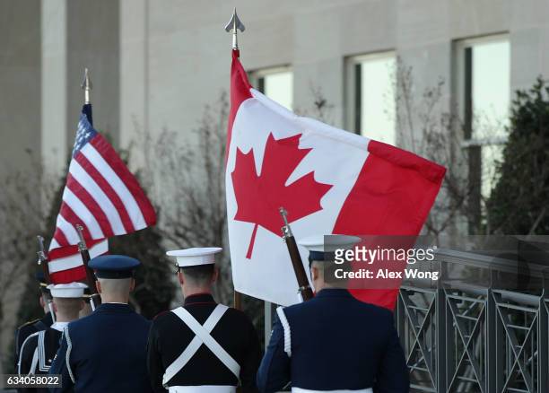 Honor guards march away with a U.S. And a Canadian flag after a honor cordon to welcome Canadian National Defense Minister Harjit Sajjan to the...