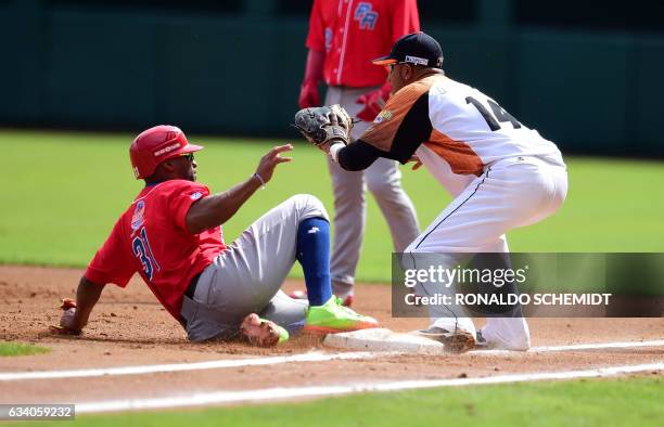 Jorge Padilla of Criollos de Caguas from Puerto Rico slides safe in first base during a Caribbean Baseball Series match against Aguilas del Zulia of...