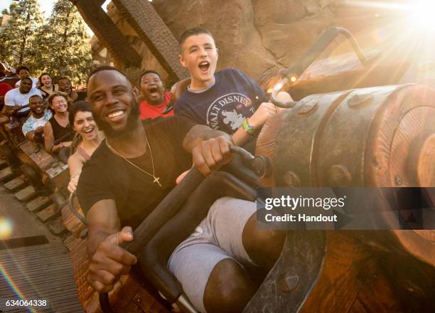 In this handout photo provided by Disney Parks, NFL Super Bowl star running back James White joins his family, friends and a lucky guest at his side...