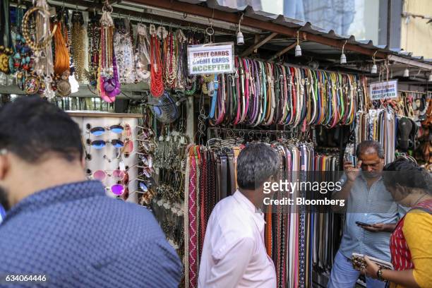 Signs reading "Debit Cards, Credit Cards Accepted" are displayed outside a clothing accessory stall at a street market in Bengaluru, India, on...