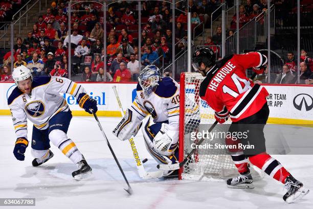 Adam Henrique of the New Jersey Devils deflects the puck off of Cody Franson of the Buffalo Sabres for a second period goal past Robin Lehner at...