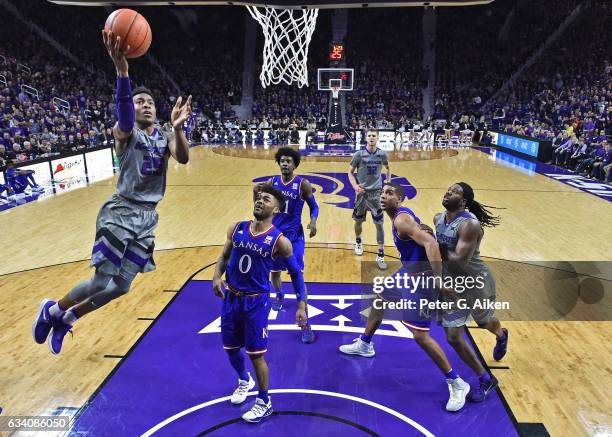 Guard Wesley Iwundu of the Kansas State Wildcats drives to the basket past guard Frank Mason III of the Kansas Jayhawks during the first half on...