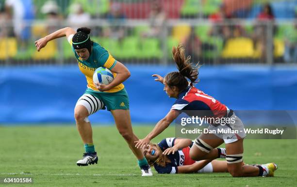 Emilee Cherry of Australia makes a break past Ryan Carlyle of the United States during the Women's Rugby Sevens Pool A match between Australia and...