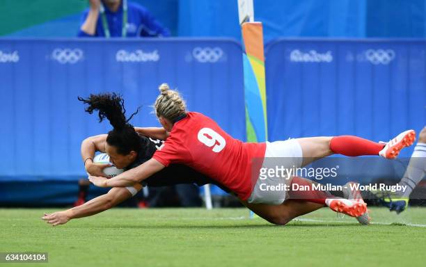 Portia Woodman of New Zealand dives over for a try under pressure from Natasha Hunt of Great Britain during the Women's Rugby Sevens Semi Final match...