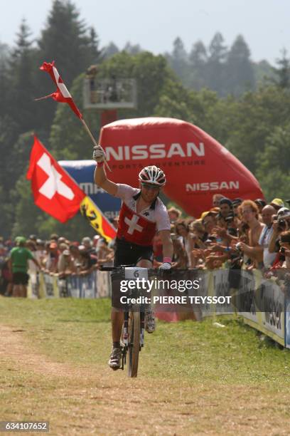 Florian Vogel of Switzerland celebrates and holds the Swiss flag after winning the silver medal at the final of the cross country elite men at the...