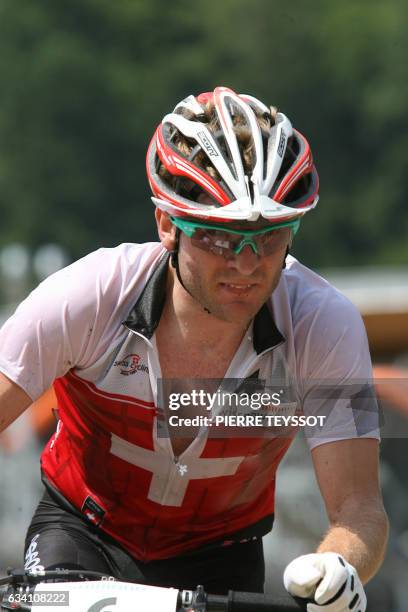 Florian Vogel of Switzerland rides before crossing the finish line to win the silver medal at the final of the cross country elite men at the UCI...